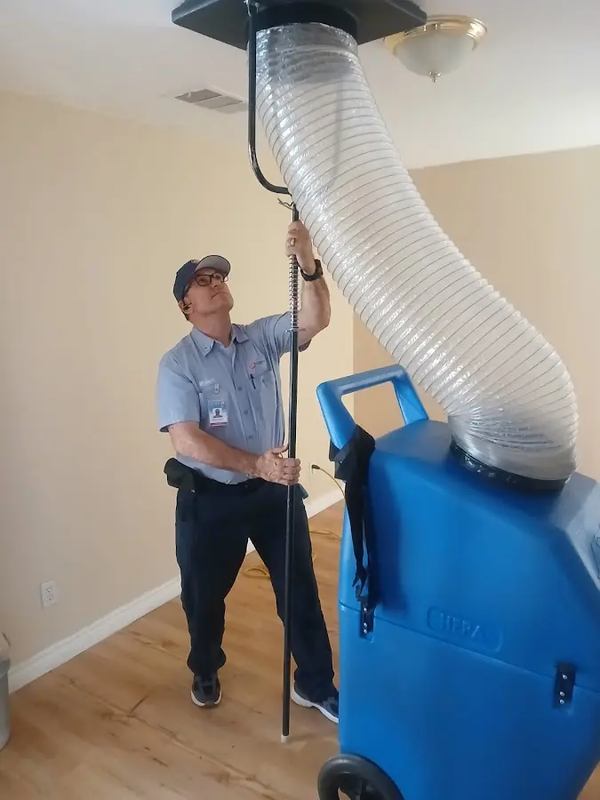 Furnace Tune-Up technician using HEPA equipment in Lansing